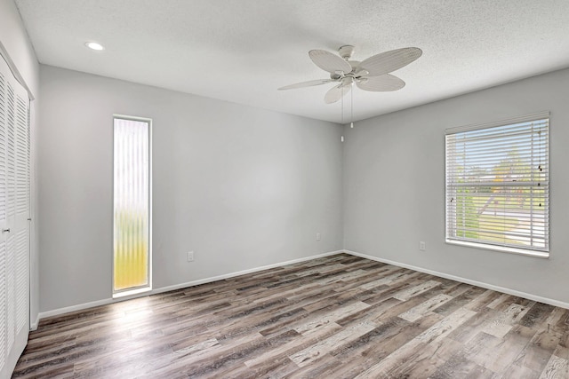 unfurnished room featuring ceiling fan, a textured ceiling, baseboards, and wood finished floors