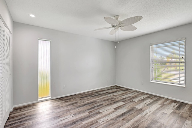 empty room featuring a textured ceiling, wood-type flooring, and ceiling fan