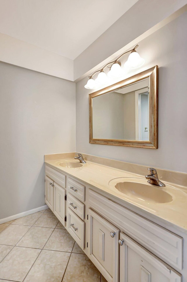 bathroom with double vanity, a sink, baseboards, and tile patterned floors