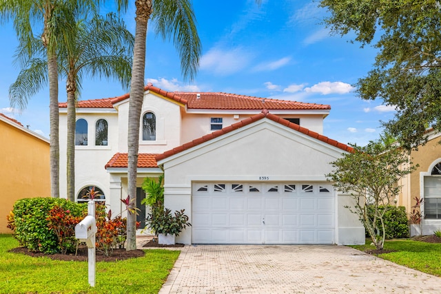 mediterranean / spanish home featuring a garage and a front yard