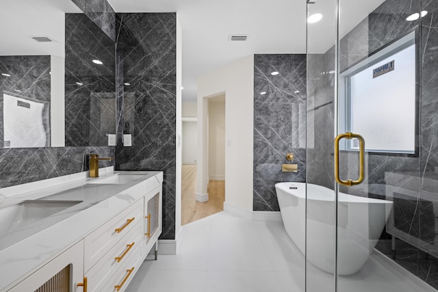 bathroom featuring tile walls, tile patterned flooring, vanity, and shower with separate bathtub