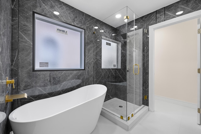 bathroom with tile walls, independent shower and bath, and tile patterned floors