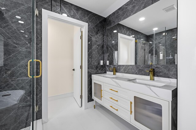 bathroom with tile walls, a shower with door, and vanity