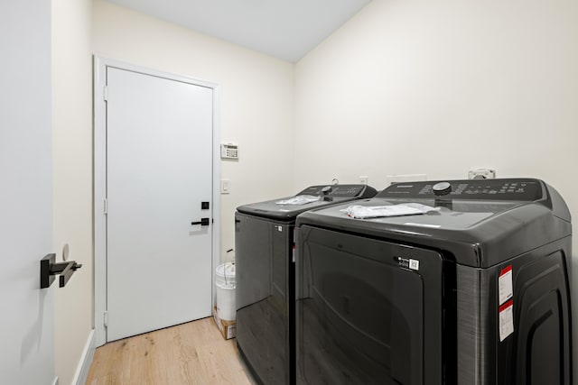 washroom featuring washer and clothes dryer and light hardwood / wood-style floors