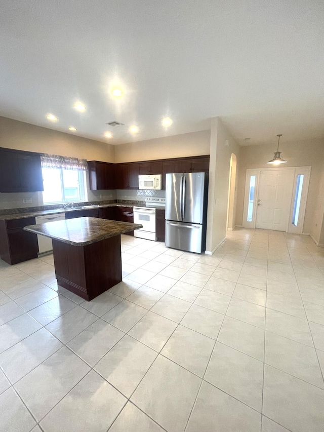 kitchen with ceiling fan, light tile patterned floors, a kitchen island, and white appliances