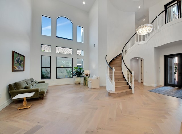 foyer with plenty of natural light, a chandelier, and light parquet floors