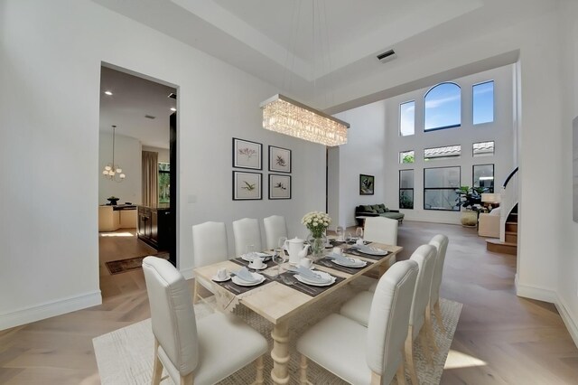 living room with a towering ceiling, light parquet flooring, and a wealth of natural light