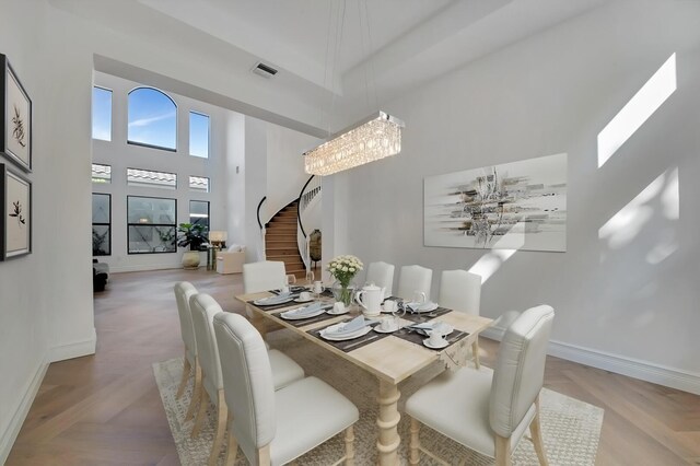 dining room with a notable chandelier, a high ceiling, and light parquet floors