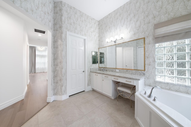 full bathroom with a bath, visible vents, baseboards, tile patterned flooring, and vanity
