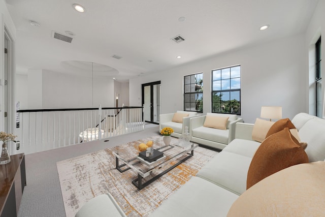 carpeted living area with visible vents and recessed lighting