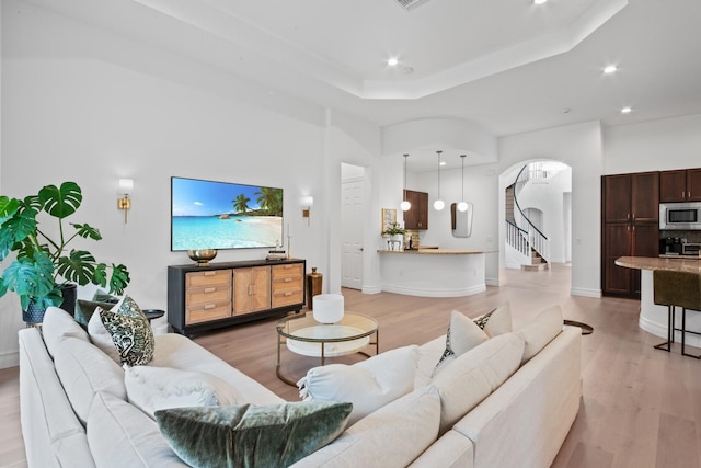 living room with a raised ceiling and hardwood / wood-style floors