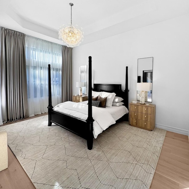 bedroom with an inviting chandelier and light hardwood / wood-style floors