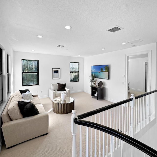 living room featuring a textured ceiling and light colored carpet