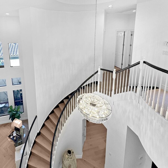 stairs featuring hardwood / wood-style floors and a towering ceiling