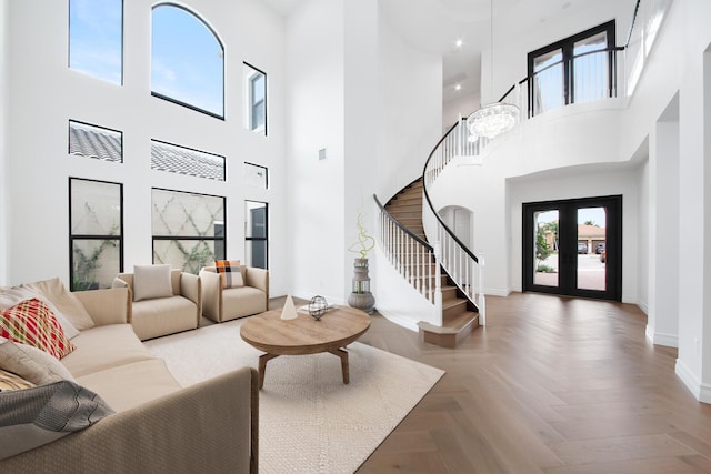 living room featuring stairway, a high ceiling, baseboards, and visible vents