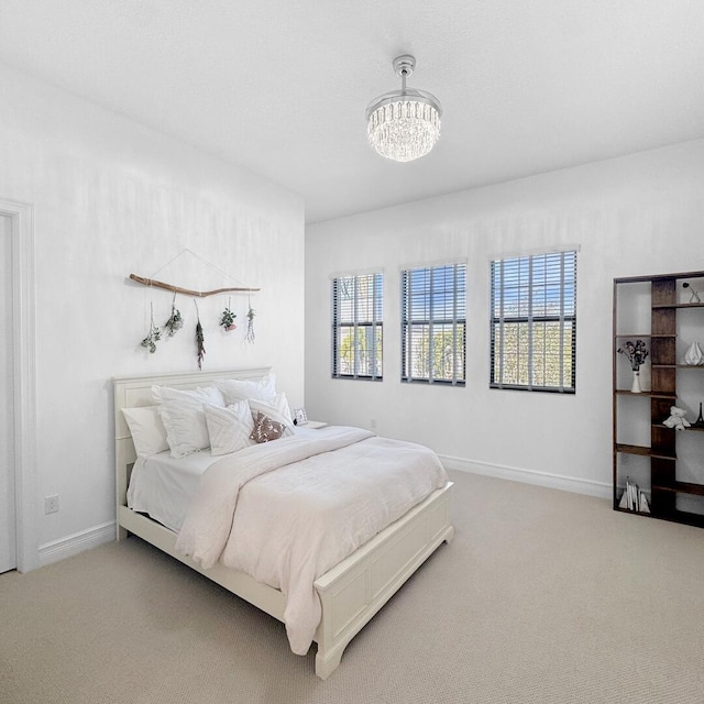 bedroom with a notable chandelier and carpet flooring