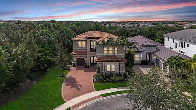 mediterranean / spanish house with a garage and a lawn