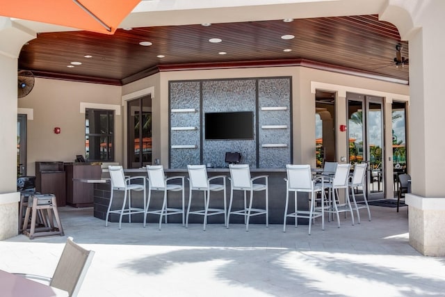 view of patio / terrace with ceiling fan and an outdoor bar