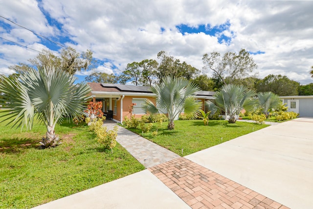 ranch-style home with solar panels and a front yard