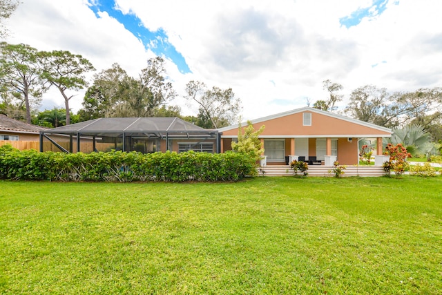 back of property featuring a lawn, glass enclosure, and covered porch