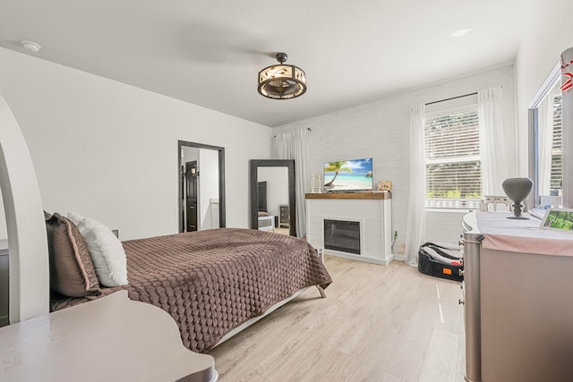 bedroom featuring light hardwood / wood-style floors and a fireplace