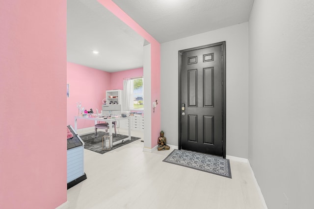 entrance foyer with a textured ceiling and light hardwood / wood-style floors