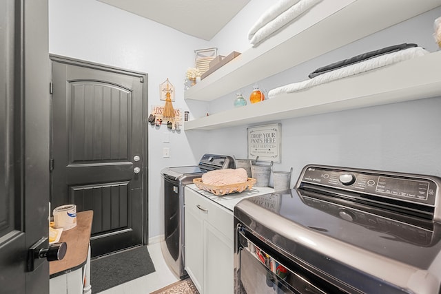 washroom with cabinets and washer and clothes dryer