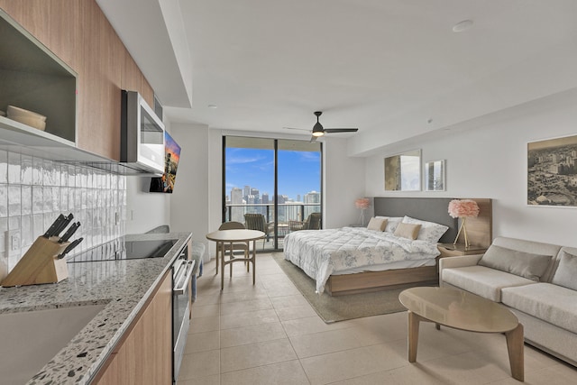 bedroom featuring ceiling fan, access to exterior, light tile patterned floors, and sink