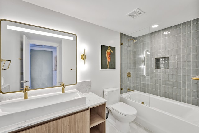 full bathroom with tile patterned flooring, tiled shower / bath combo, vanity, and toilet