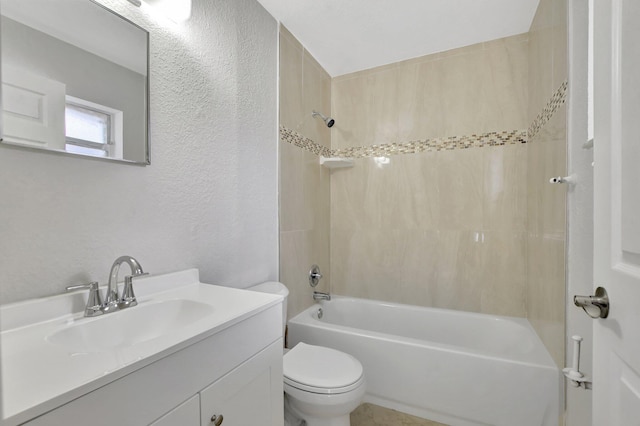 full bathroom featuring vanity, tiled shower / bath, and toilet