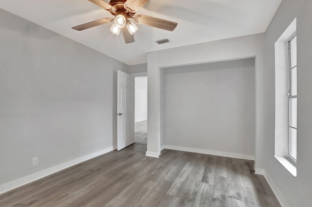 unfurnished bedroom with a closet, wood-type flooring, and ceiling fan