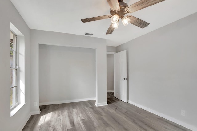 unfurnished bedroom with ceiling fan, light wood-type flooring, and a closet