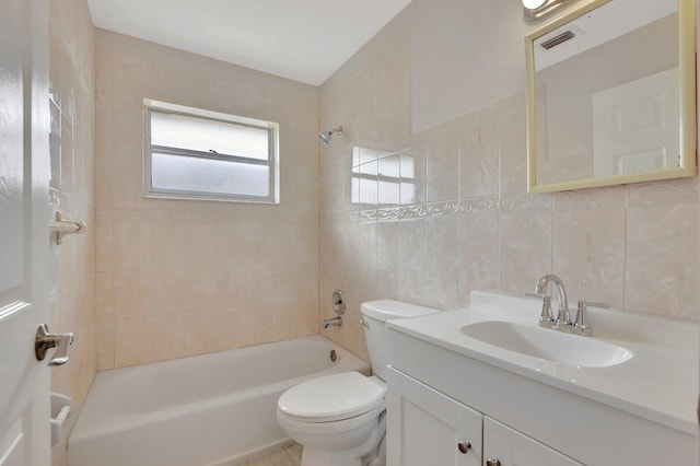 full bathroom featuring tiled shower / bath, vanity, tile walls, toilet, and decorative backsplash