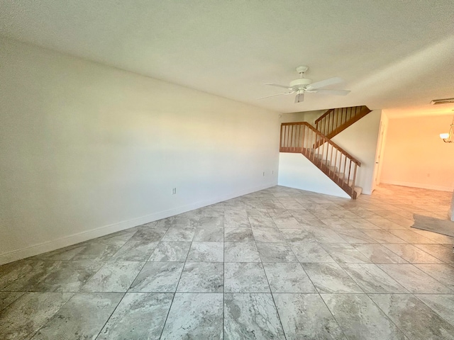 unfurnished room with ceiling fan and a textured ceiling