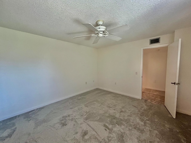 empty room with ceiling fan, carpet floors, and a textured ceiling