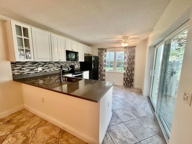 kitchen featuring black appliances, decorative backsplash, white cabinetry, and kitchen peninsula