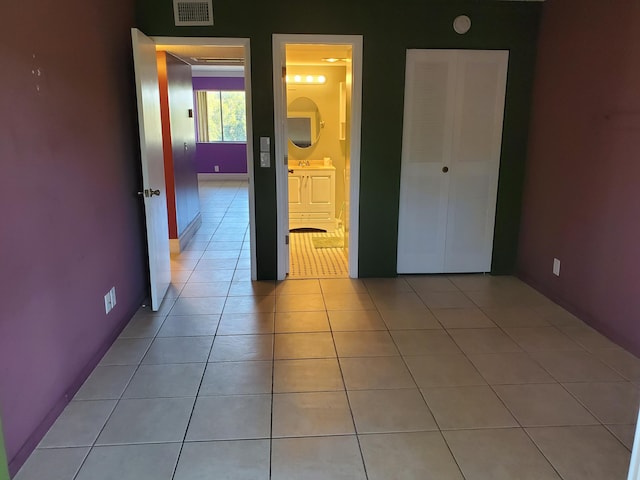 interior space featuring connected bathroom and light tile patterned floors