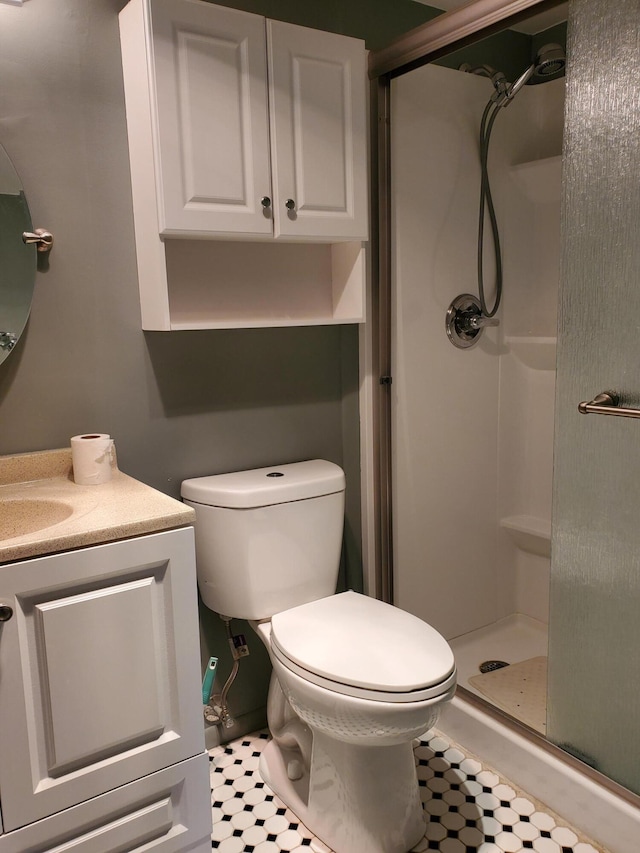 bathroom with vanity, a shower with shower door, and toilet