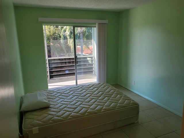 unfurnished bedroom featuring a textured ceiling and light tile patterned floors