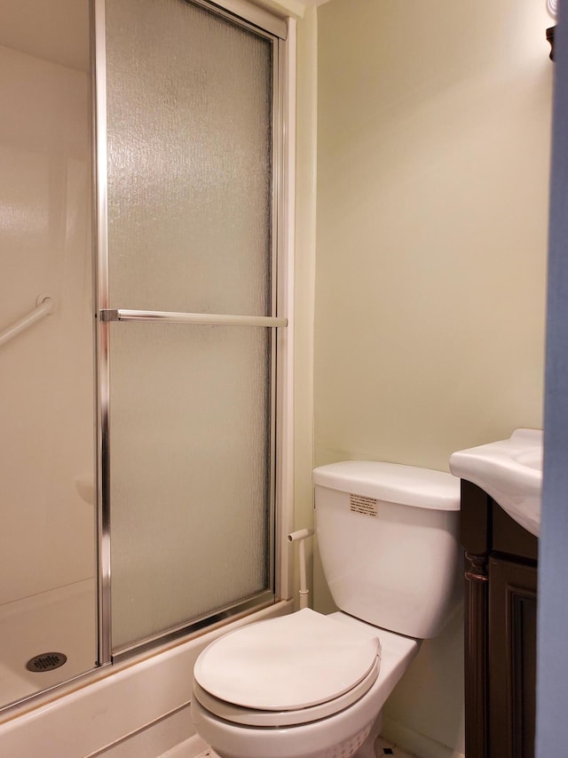 bathroom featuring walk in shower, vanity, and toilet