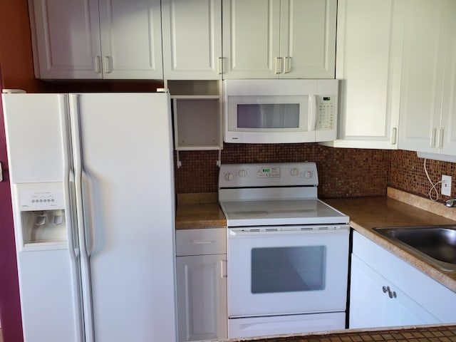 kitchen featuring white appliances, sink, white cabinets, and tasteful backsplash