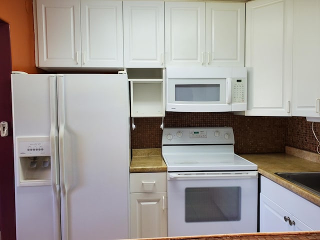 kitchen featuring white cabinets, tasteful backsplash, and white appliances