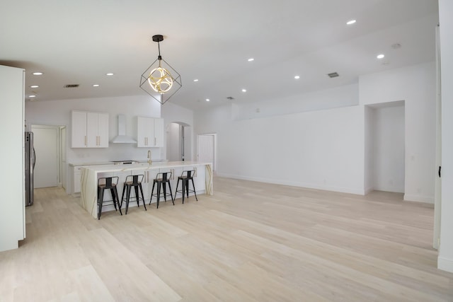 kitchen featuring ceiling fan, an island with sink, sink, stainless steel dishwasher, and vaulted ceiling