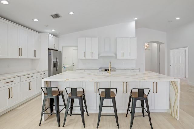 empty room with lofted ceiling, ceiling fan, and light hardwood / wood-style flooring