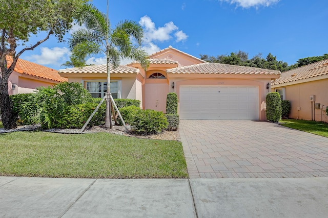 mediterranean / spanish-style house with a garage and a front yard