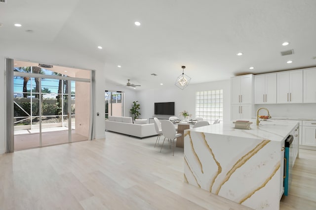 foyer with ceiling fan with notable chandelier and light hardwood / wood-style floors