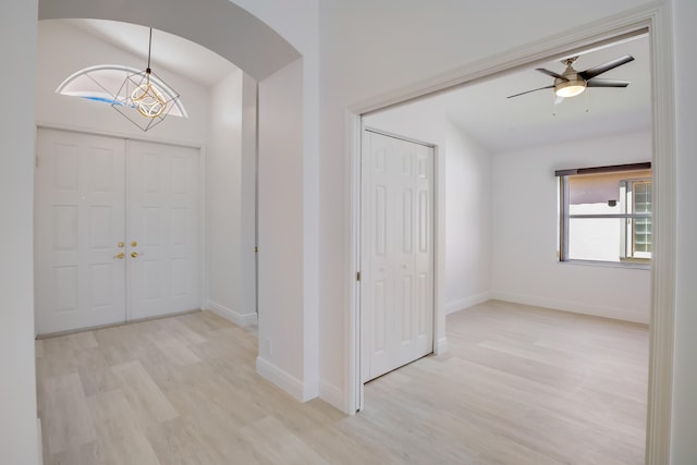 kitchen featuring stainless steel fridge, white cabinets, wall chimney exhaust hood, a kitchen bar, and a spacious island