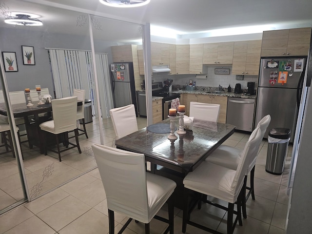 dining space with light tile patterned flooring and sink