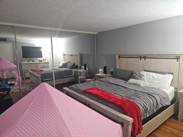 bedroom featuring a textured ceiling and hardwood / wood-style floors