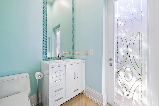 bathroom with wood-type flooring, vanity, and toilet